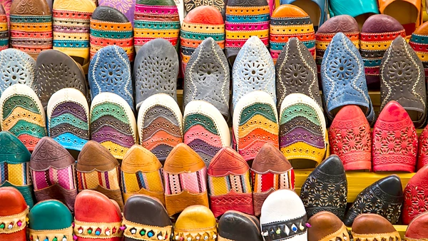 Babuchas de cuero bordadas y caladas, alineadas en un puesto del zoco