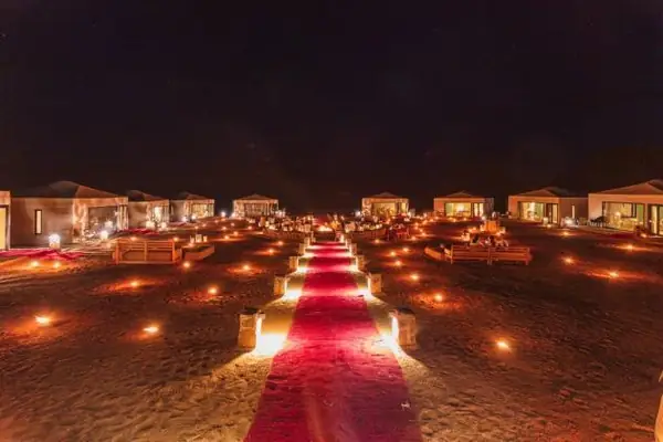Camino de farolillos y alfombra roja en el desierto, de noche