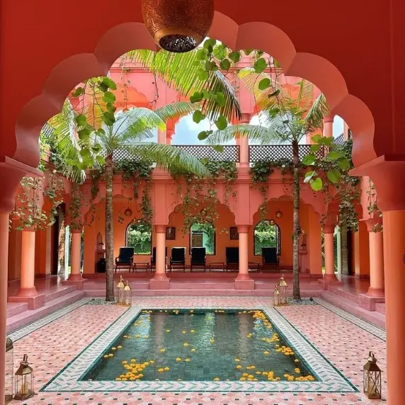 Patio de riad de muros rojos, estanque y arcadas, Marrakech