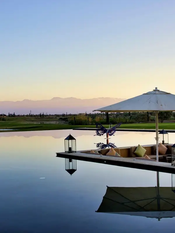 Lago y salón exterior junto a un campo de golf, Atlas al fondo, Marrakech