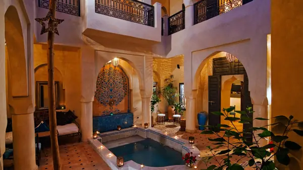 Patio de riad con estanque, arcadas y zellige