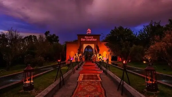 Camino de farolillos y alfombra roja hacia un palacio iluminado, Marrakech